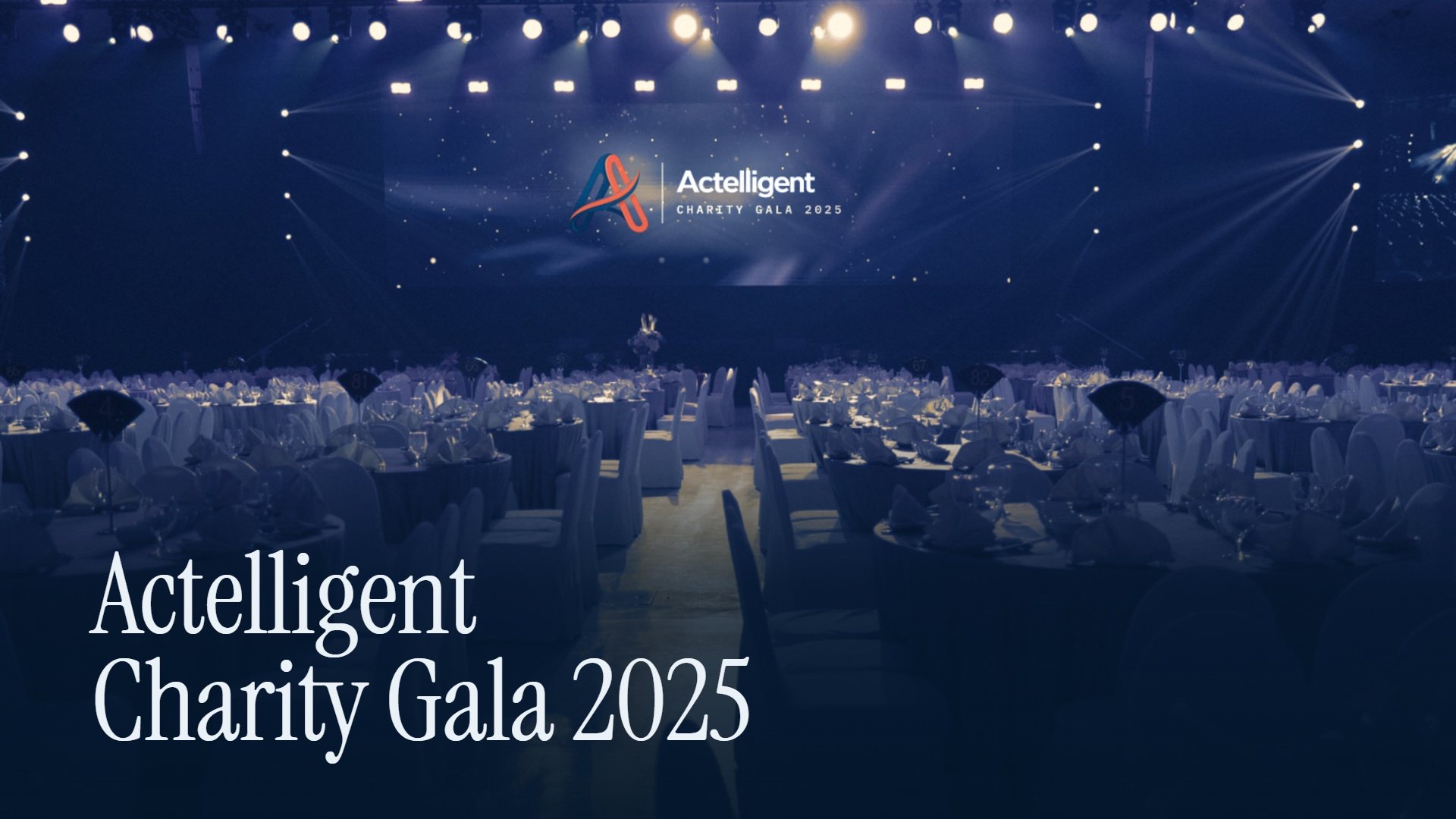 Actelligent Charity Gala 2025 — the ballroom set for dinner beneath the Actelligent screen
